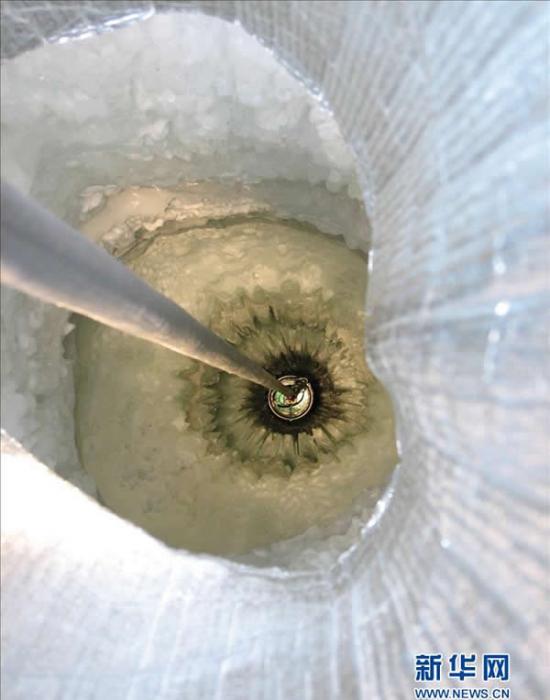 由美国国家科学基金会提供的照片显示的是钢缆串联的光学传感器深入冰层。