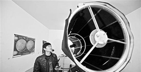 在长沙的湖南天文爱好者协会工作室里，谭巍在对自制的望远镜进行调试。