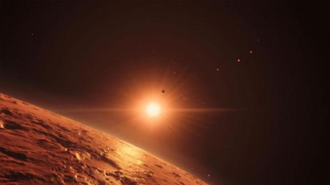 这幅绘图想像从TRAPPIST-1恒星系统中的一颗行星往外看的景象，这颗恒星拥有七颗和地球大小相近的行星。 ILLUSTRATION BY M. KORNMES