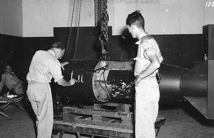 弗朗西斯・伯奇（Francis Birch）在即将投放于广岛的原子弹上写下“小男孩”，站在右边的诺曼・拉姆齐（Norman Ramsey）正在观看