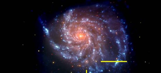 可见光和紫外线下，Swift卫星拍摄的M101星系照片，黄色线代表超新星SN2011fe的位置。照片是伪彩色的，蓝色表示紫外线部分，红色表示可见光部分。