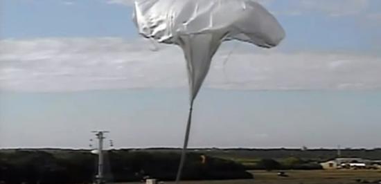 气球升空，把飞碟状飞行器送上高空。