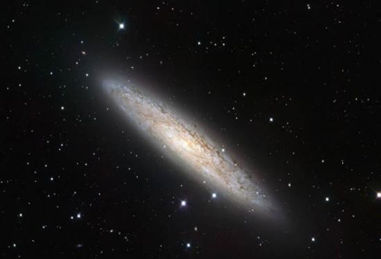 VLT巡天望远镜捕捉到临近旋转星系NGC253的细节美丽，这张最新图片可能是目前有关该天体和周围物质最好的宽敞视野。