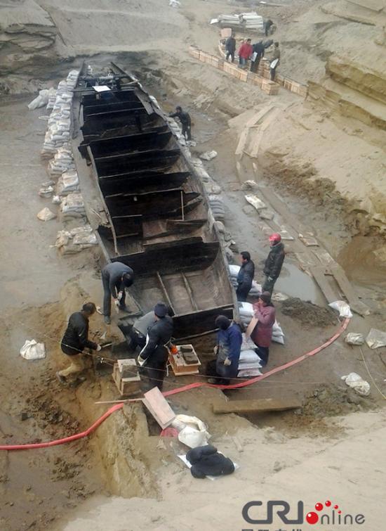 2014年1月6日，河南洛阳古沉船发掘现场，为防止古沉船受损，考古人员正在为其抹药水。