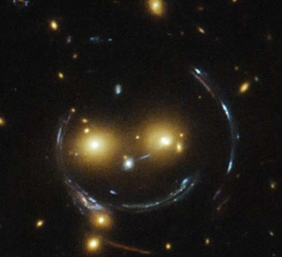 微笑星系：它的两只眼睛实际上是两个明亮的星系，而那大大的笑容，实际上是由于强烈的引力透镜效应产生的虚像。
