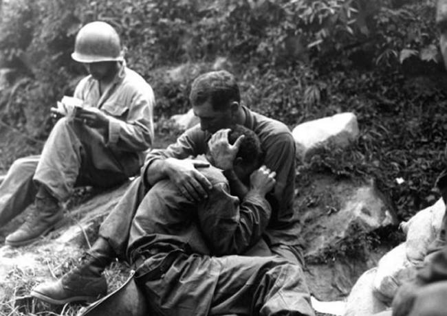 美国士兵抱着痛哭的同伴。