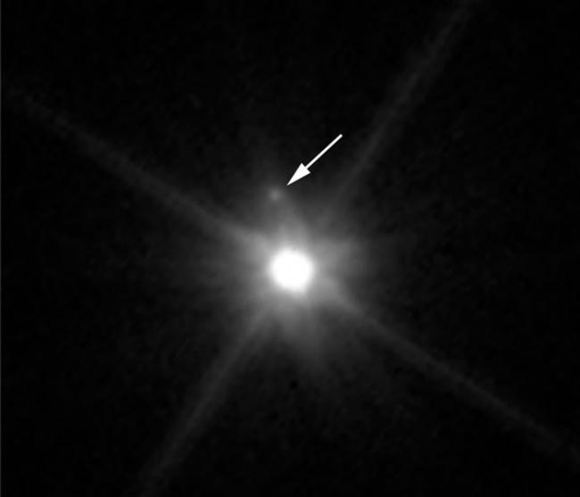 这张由哈勃空间望远镜拍摄的图像显示出鸟神星被发现的第一颗卫“MK 2”。这颗小卫星在图像中位于鸟神星上方，由于鸟神星强烈的光辉，它相比之下显得非常暗弱，几乎难以