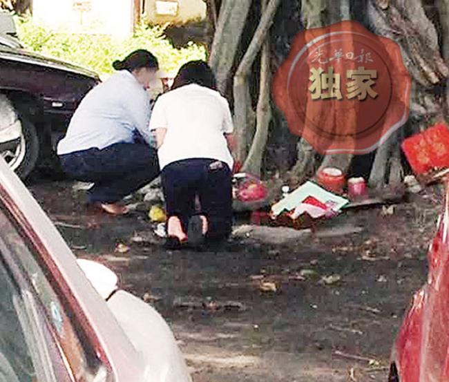 校园疑发生集体中邪后，有华裔家长带孩子在校门外进行膜拜仪式，以祈求平安。（图／翻摄《光华日报》）