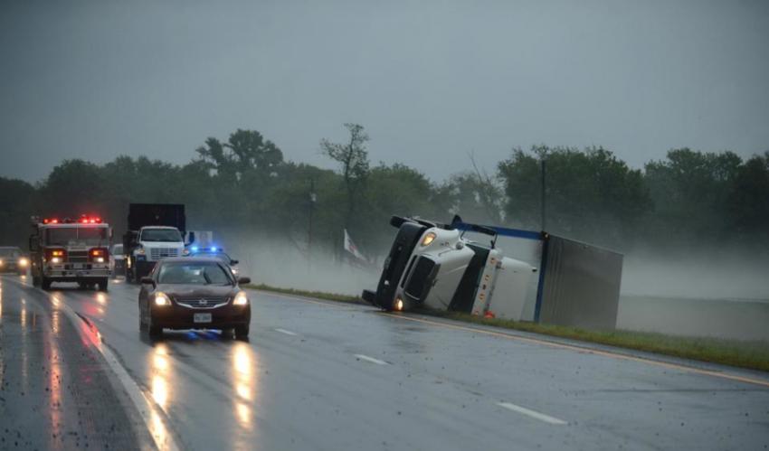 受到龙卷风袭击，一辆卡车倒在路边。