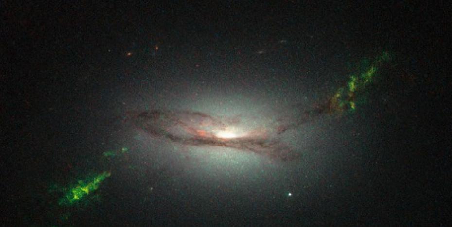 哈勃望远镜拍摄的图像显示，绿色光芒就像是星系碰撞后留下的痕迹，实则为超级黑洞的辐射爆炸所致。