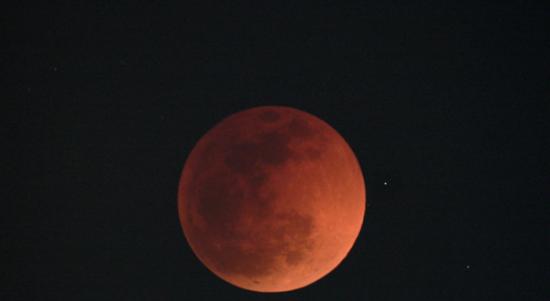 月全食期间的月亮呈现暗红色，故称血月。（图：台湾中央气象局）