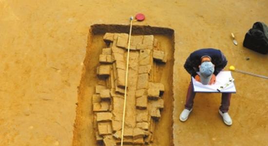 考古人员在对发掘出的“砖棺”进行绘图。