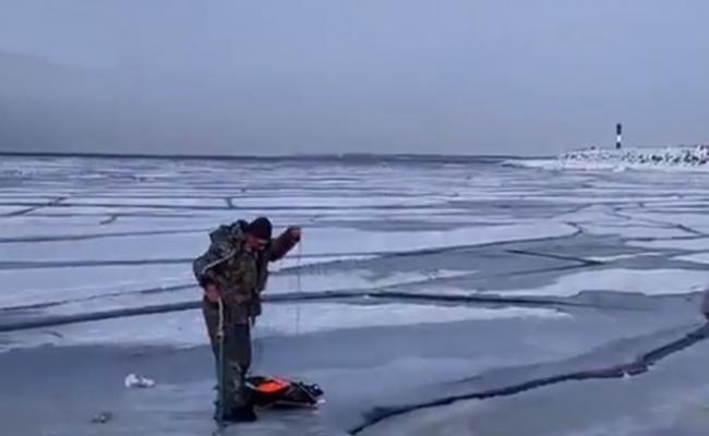 另一名钓友淡定地在裂冰面上准备垂钓。