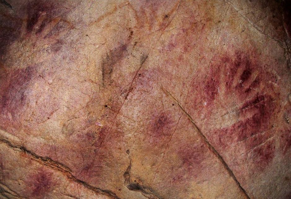 西班牙北部卡斯蒂略洞穴内的掌印。中央有一个红色圆盘，年代在超过4 万800 年前，是欧洲最古老的洞穴艺术。摄影：João Zilhã