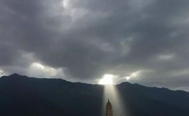 一道“佛光”穿破厚重的云海，直接照射在崇圣寺三塔。