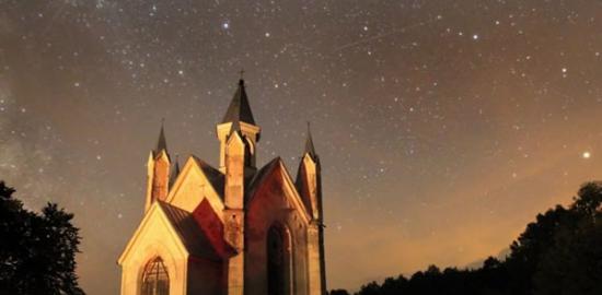 距离白俄罗斯明斯克100公里的一座天主教教堂，摄影师拍摄到英仙座流星雨划过夜空
