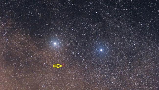 半人马座Proxima（黄箭头）类似太阳，两颗行星（图中光点）围着它公转。