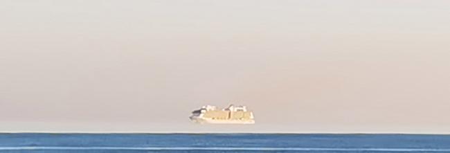 海市蜃楼“上蜃景”：英国男子在多塞特郡伯恩茅斯海岸拍到巨大邮轮飘浮在空中